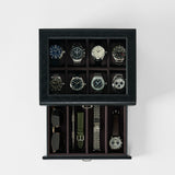 The TAWBURY Bayswater 8 Slot Watch Box with Storage in Black/Charcoal stylishly displays eight watches under a glass top and features a lower drawer for storing sunglasses, straps, and an additional watch.