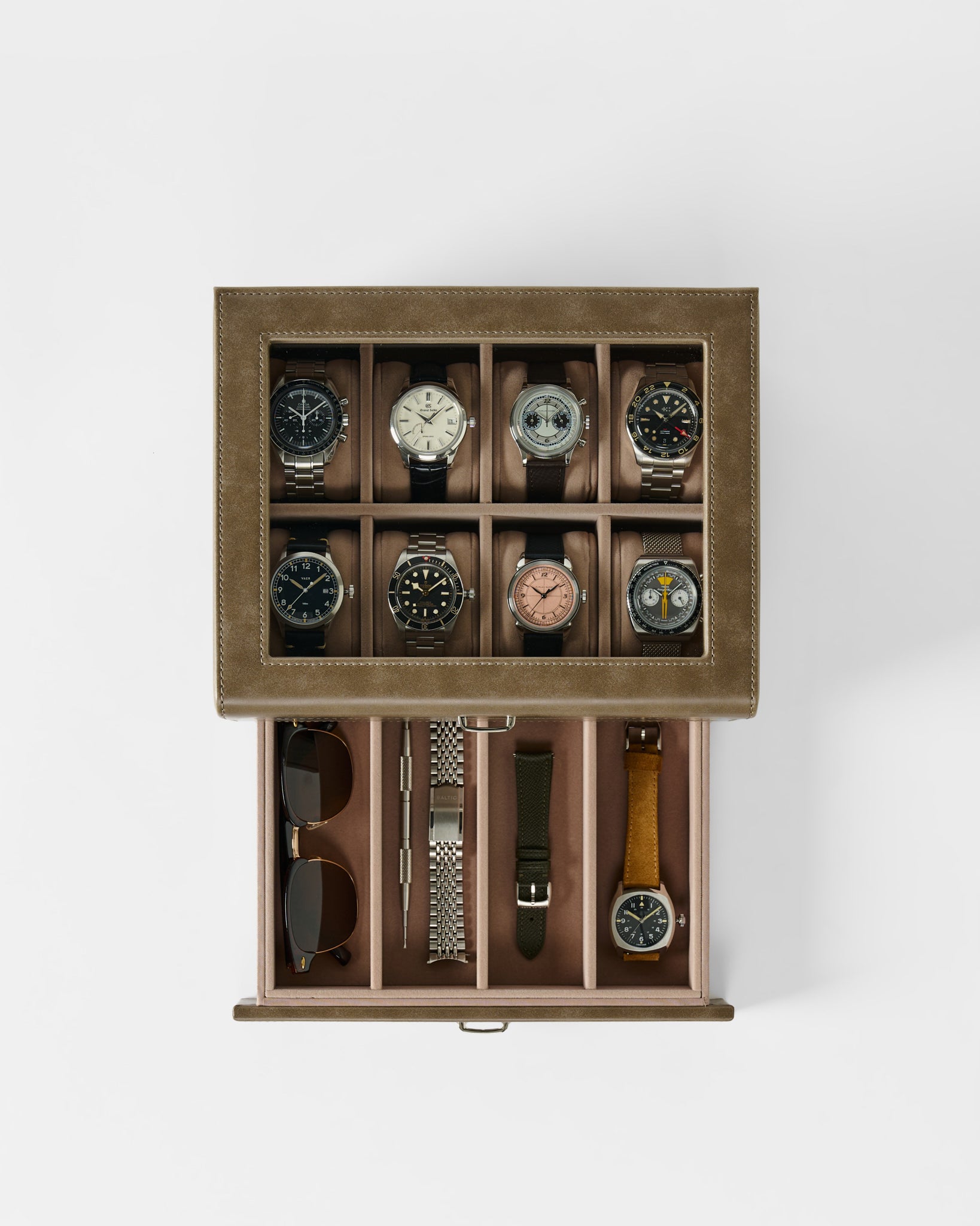 The TAWBURY Bayswater 8 Slot Watch Box with Storage in taupe keeps eight wristwatches, a pair of sunglasses, three watch straps, and a metal bracelet neatly organized in separate compartments.
