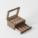 The TAWBURY Bayswater 8 Slot Watch Box with Storage in Driftwood Taupe features a glass lid, upper slots for rings or watches, and an open drawer below with compartments for extra watch storage.
