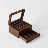 The TAWBURY Bayswater 8 Slot Watch Box with Storage in Chestnut Brown features a glass lid, multiple compartments for watches, and an open drawer with extra space.