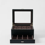 The TAWBURY Bayswater 8 Slot Watch Box with Storage in Midnight Black features a glass lid, eight watch compartments on top, and an open drawer with extra sections, displayed against a plain white background.