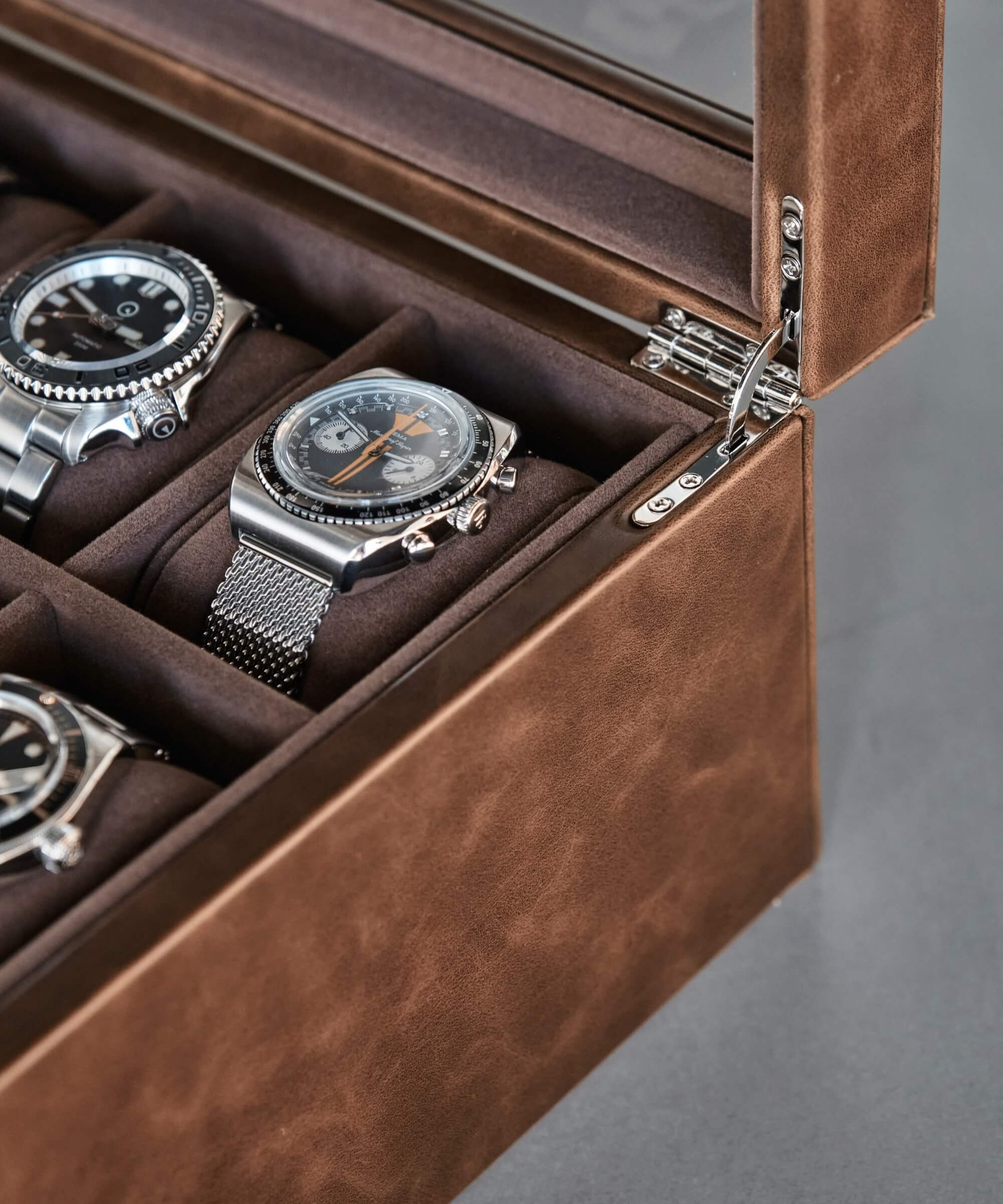 A collection of TAWBURY Bayswater 8 Slot Watch Box with Drawer - Brown in a men's watch case.
