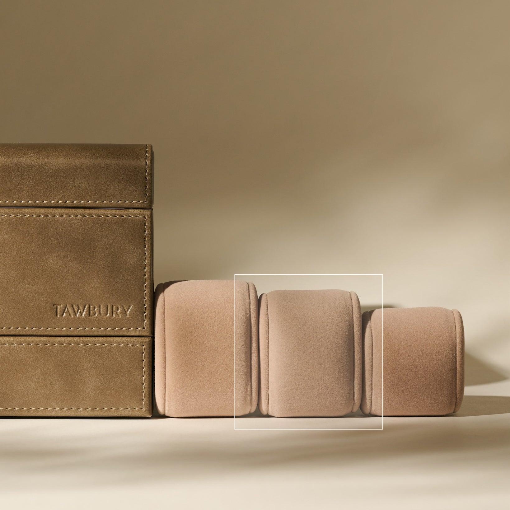 Three Bayswater Watch Pillows (Beige, 55mm, Small) by TAWBURY are placed side by side on a neutral background, featuring a minimalist design and "TAWBURY" embossed on the middle pillow.
