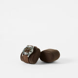 A TAWBURY Bayswater Watch Pillow in Graphite (50mm, X-Small) with a brown-strap wristwatch rests on a plain white background next to an empty matching cushion, both showcasing stylish Bayswater accessories.