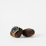 The TAWBURY Bayswater Watch Pillows in Graphite (55mm, X-Small) are displayed on a brown cushioned holder, with an empty slender pillow beside them, set against a plain white background.