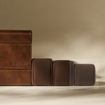 Four TAWBURY Bayswater Watch Pillows in graphite (55mm X-Small) are arranged in a row on a beige surface with a neutral background.