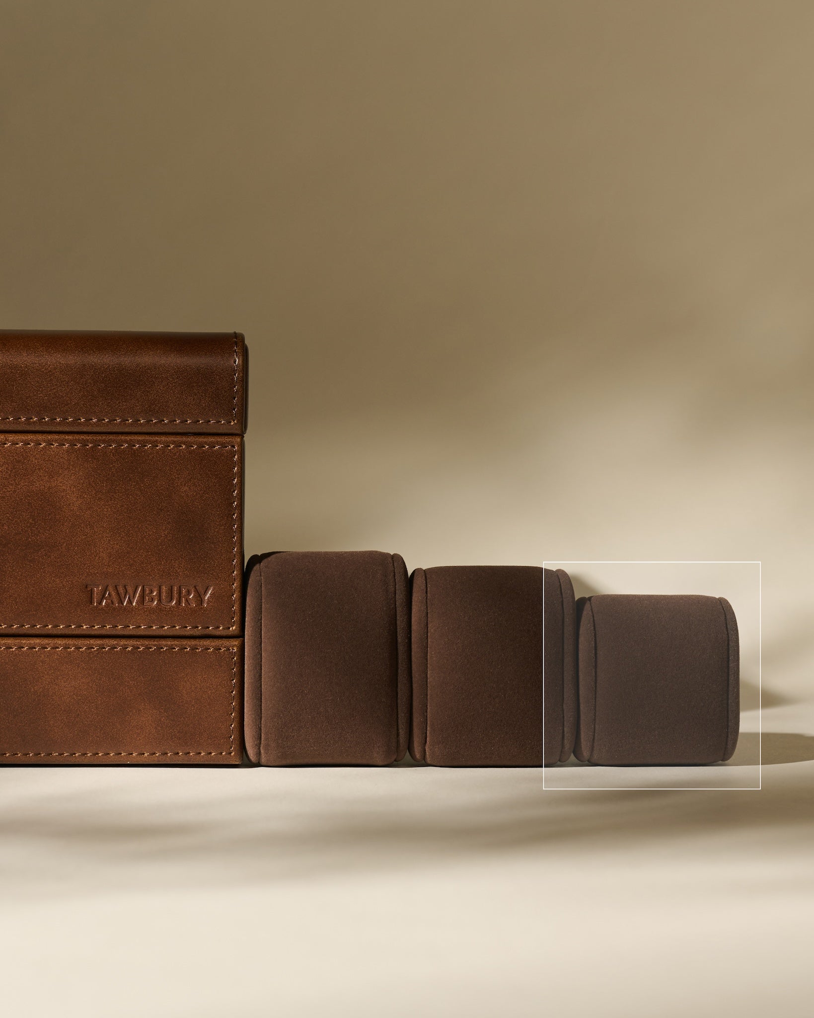 Four TAWBURY Bayswater Watch Pillows in graphite (55mm X-Small) are arranged in a row on a beige surface with a neutral background.