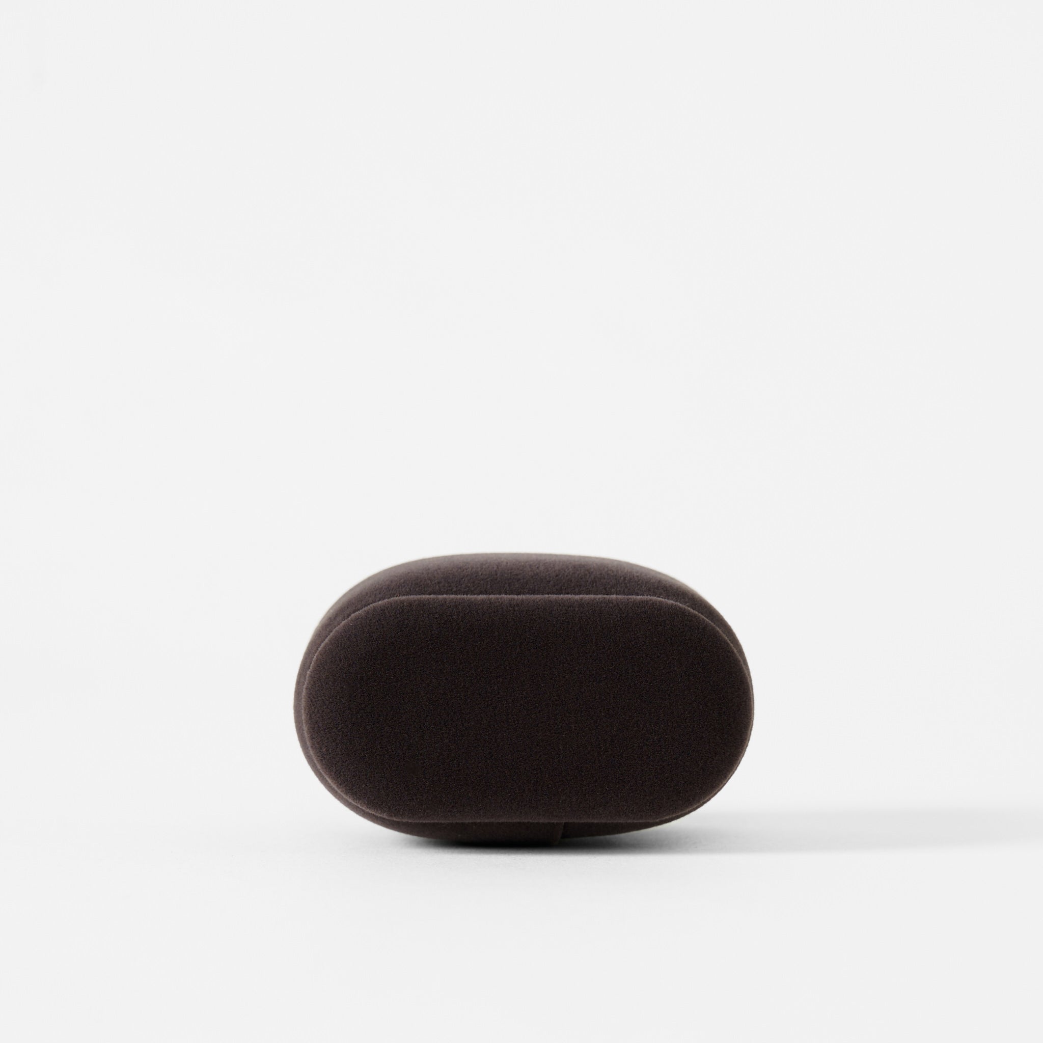 A charcoal, oval-shaped Bayswater Watch Pillow (50mm, Small) by TAWBURY stands upright against a plain white background.
