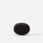 A charcoal, oval-shaped TAWBURY Bayswater Watch Pillow (50mm, X-Small) with a soft, smooth texture is centered against a plain white background.