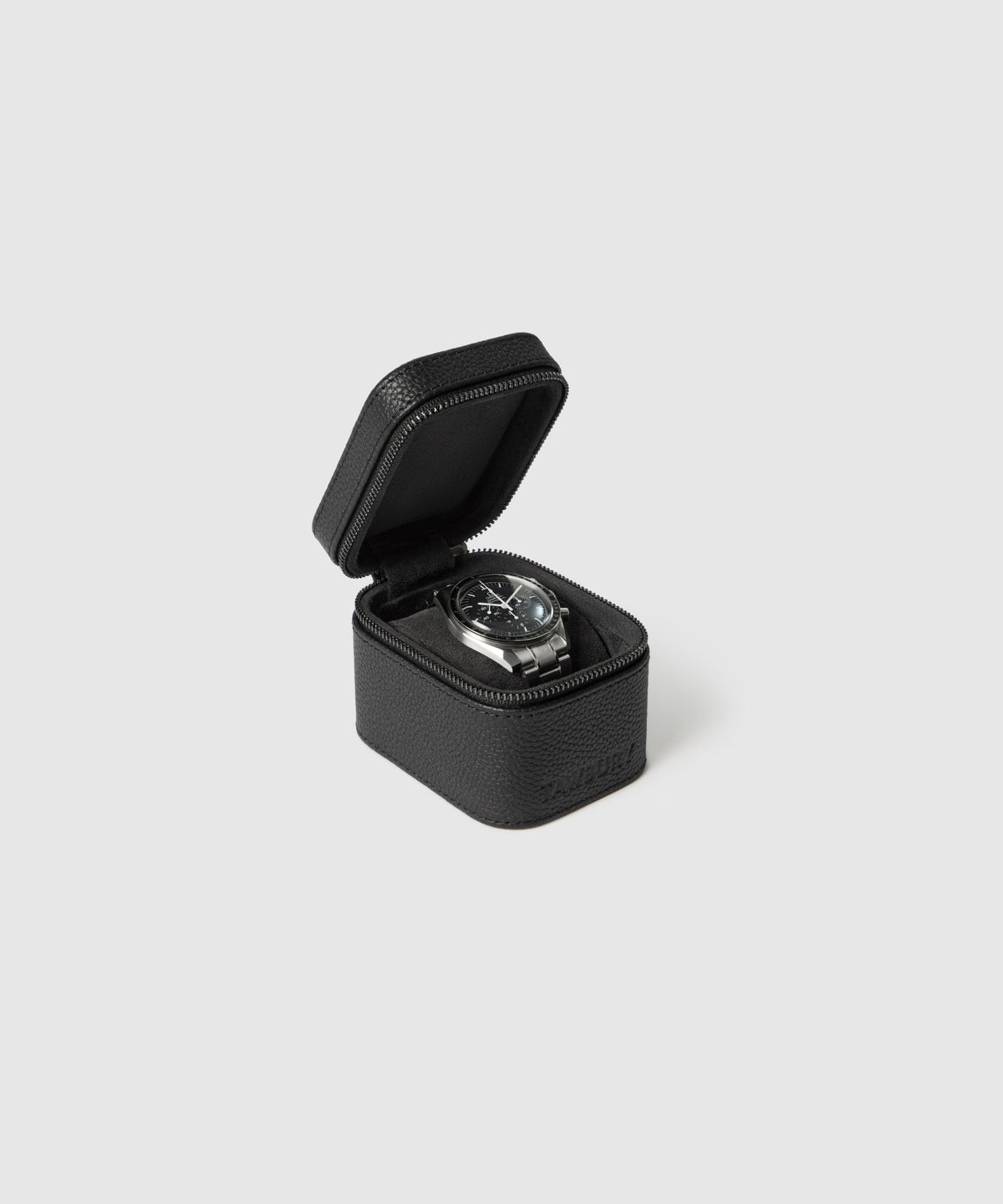 The TAWBURY Fraser 1 Watch Travel Case - Black (Coming Soon) elegantly displays a black wristwatch with a round face, offering stylish protection against a plain light gray background.
