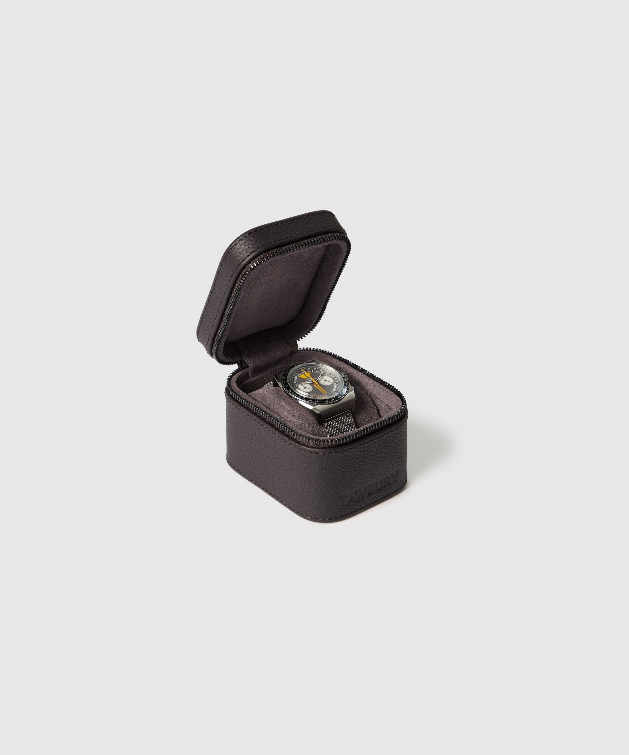 The TAWBURY Fraser 1 Watch Travel Case - Brown (Coming Soon) showcases a wristwatch with a black strap, offering style and protection against a plain light gray background.