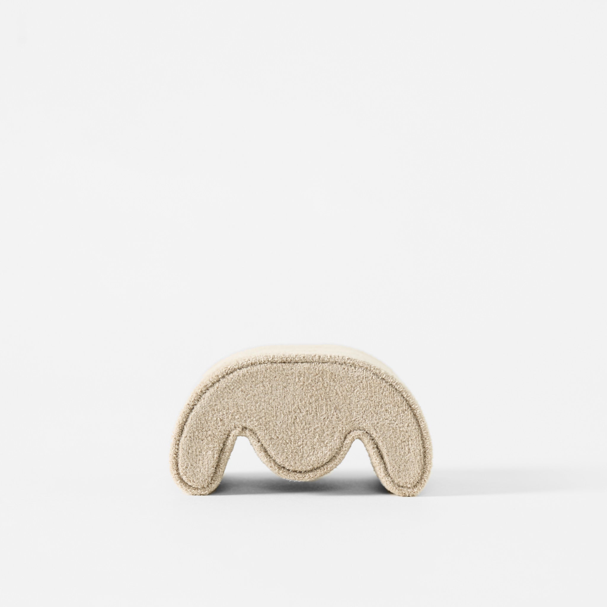 The TAWBURY Grove Watch Pillows in X-Small, beige, feature a textured finish and curved design reminiscent of Grove watch boxes, shown against a plain white background.