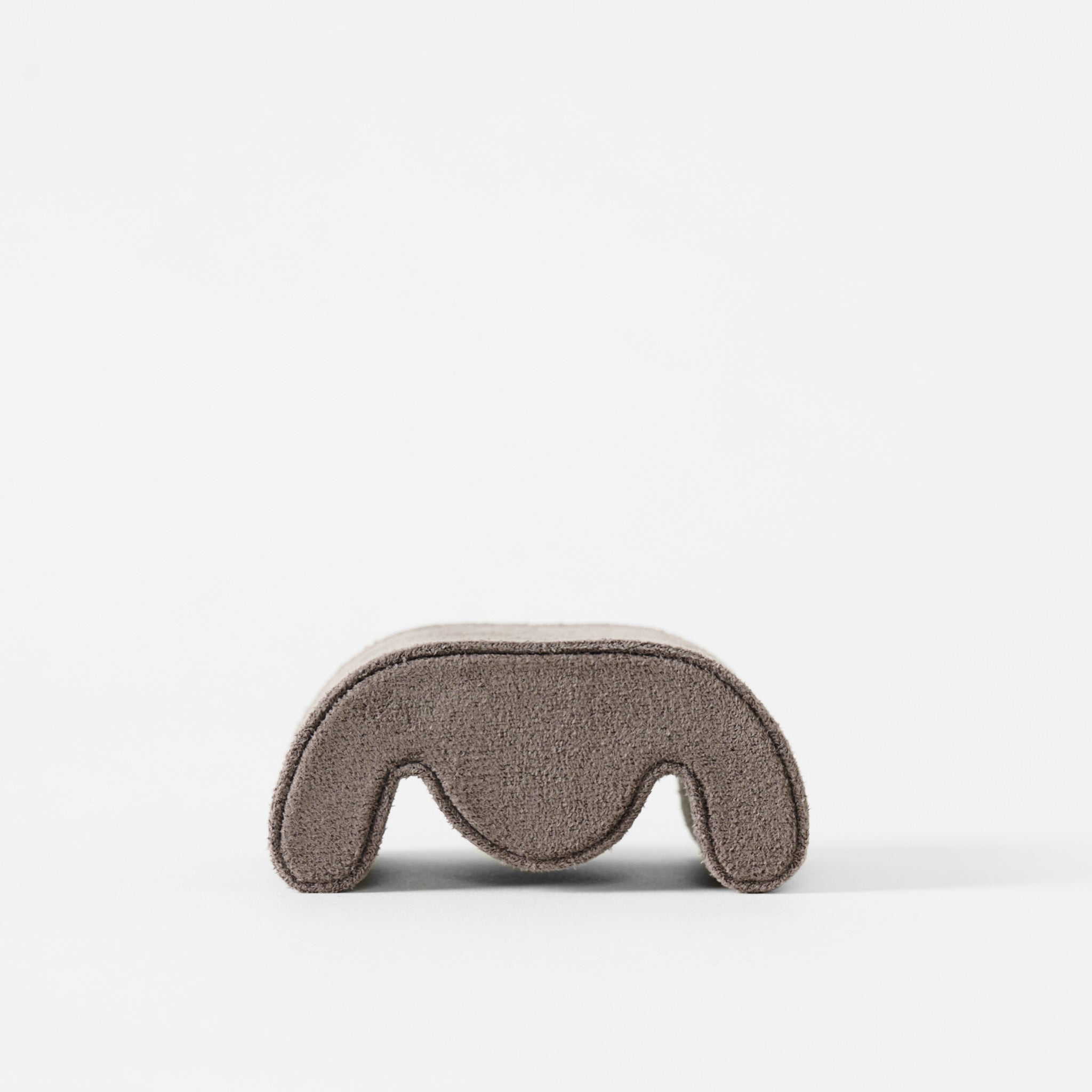 The TAWBURY Grove Watch Pillow in standard size features a soft, fabric-like texture and curved shape in brown, shown from the front against a white background.