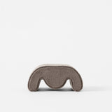 The TAWBURY Grove Watch Pillow in standard size features a soft, fabric-like texture and curved shape in brown, shown from the front against a white background.