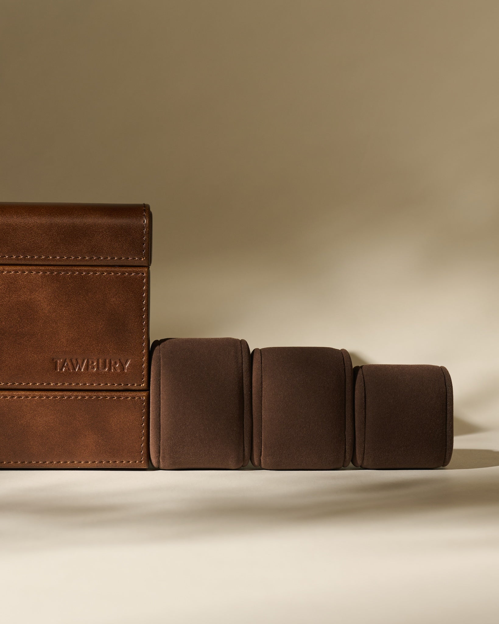 The TAWBURY Bayswater 8 Slot Watch Box with Storage in Chestnut Brown displays multiple cushioned watch holders in a stylish faux leather design, ideal for organizing and protecting your timepieces.