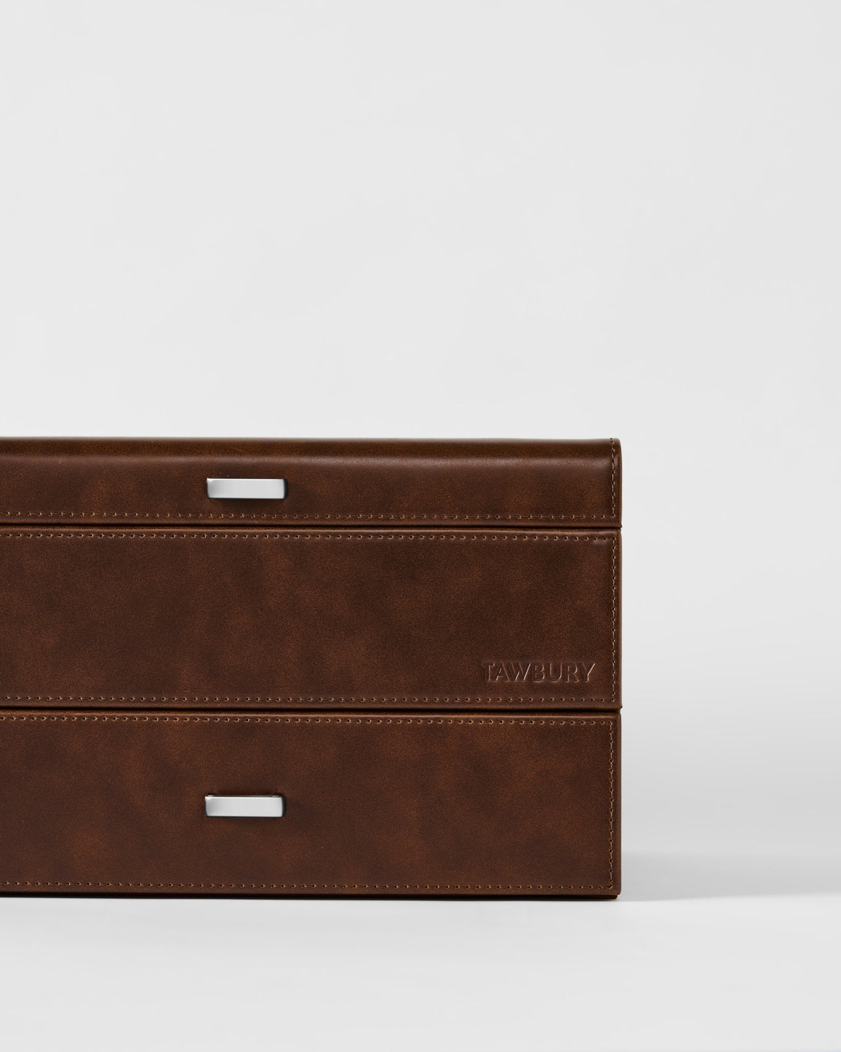 The Bayswater 6 Watch Jewelry Box by TAWBURY features brown leather, two silver handles, and "TAWBURY" embossed on the lower right side, set against a plain white background.