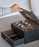 A man is opening a TAWBURY Bayswater 6 Watch Jewellery Box - Black with several timepieces in it.