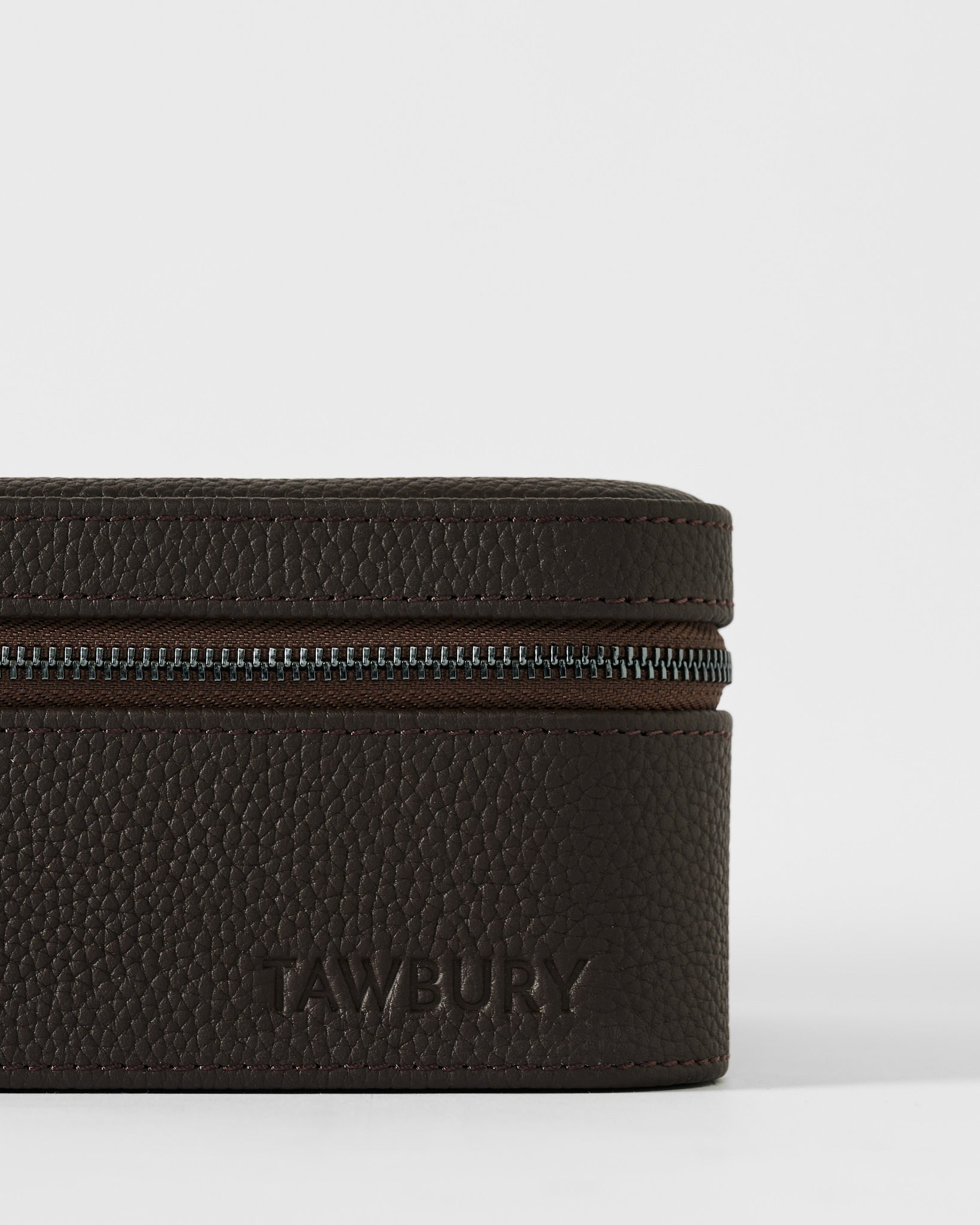 A close-up of the TAWBURY Fraser 4 Watch Case in brown textured leather, embossed with "TAWBURY" on the front—ideal for stylish storage or travel with up to 4 watches.