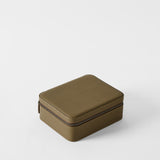 The TAWBURY Fraser 3 Watch Case with Storage in Truffle Taupe features a rectangular, brown textured leather design with rounded edges and a zipper, displayed on a plain white background.