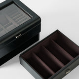 The TAWBURY Bayswater 6 Watch Jewelry Box in Black/Charcoal, made of vegan leather, features a glass lid, removable tray, and multiple compartments. Shown on a white background.