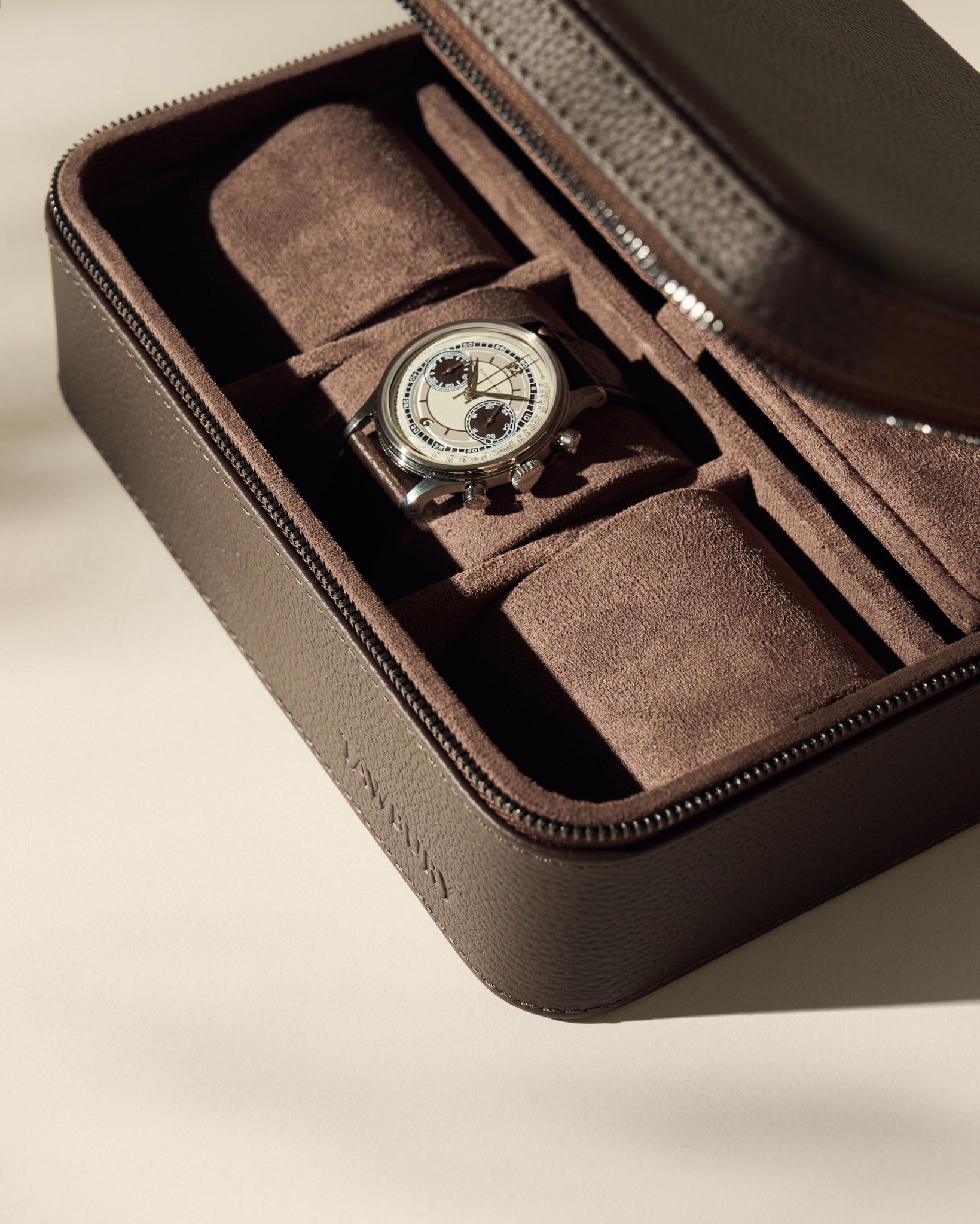 The TAWBURY Fraser 3 Watch Case with Storage in brown features a zippered leather design with suede-lined compartments for secure watch organization.