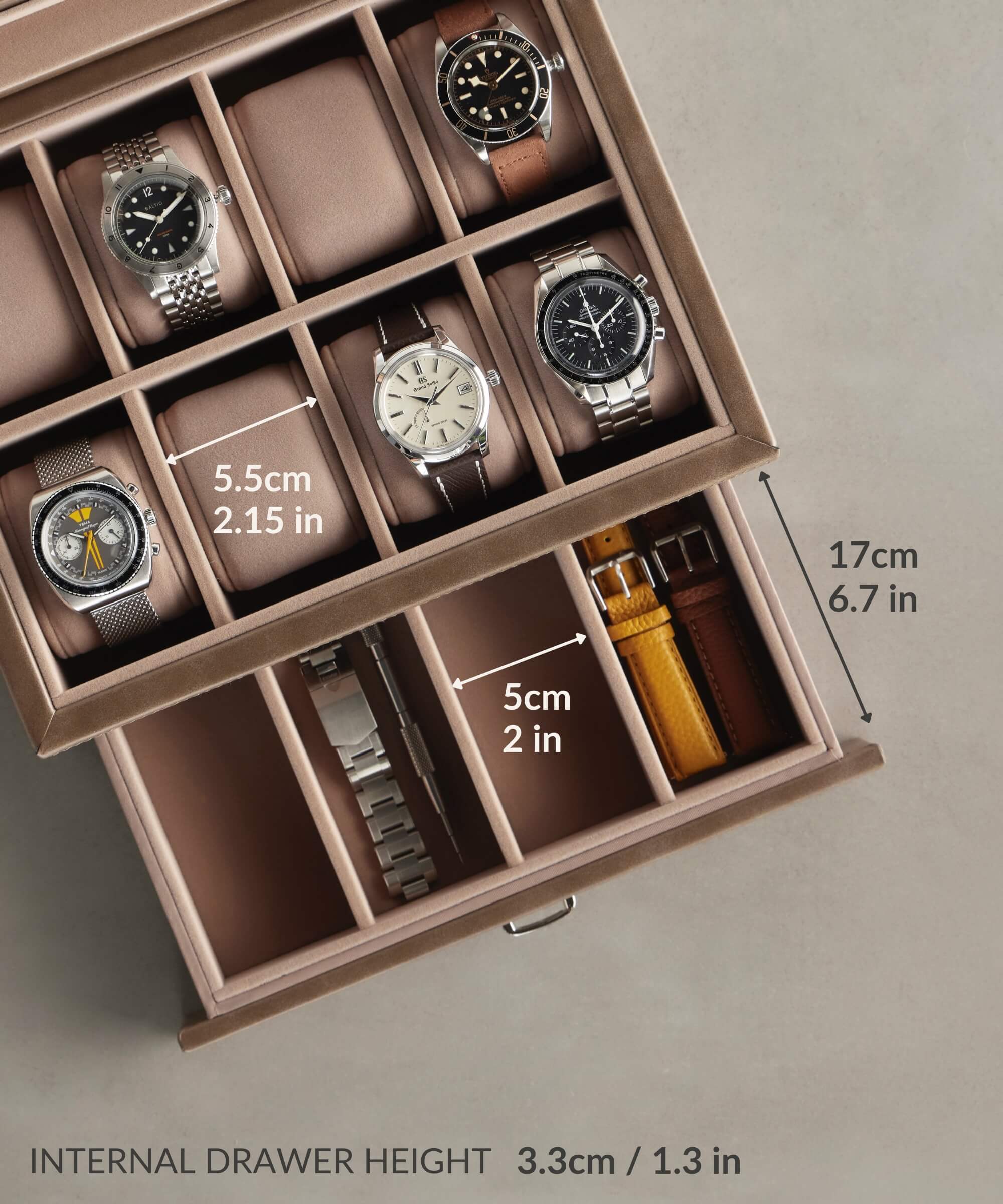 Explore the ideal watch box for any collector, the TAWBURY Bayswater 8 Slot Watch Box with Storage in Taupe. Crafted from exquisite vegan leather, it provides individual compartments for each timepiece. The storage solution measures 17cm (6.7in) high, with drawer heights of 3.3cm (1.3in) and width dimensions of 5.5cm and 5cm (2.15in and 2in).