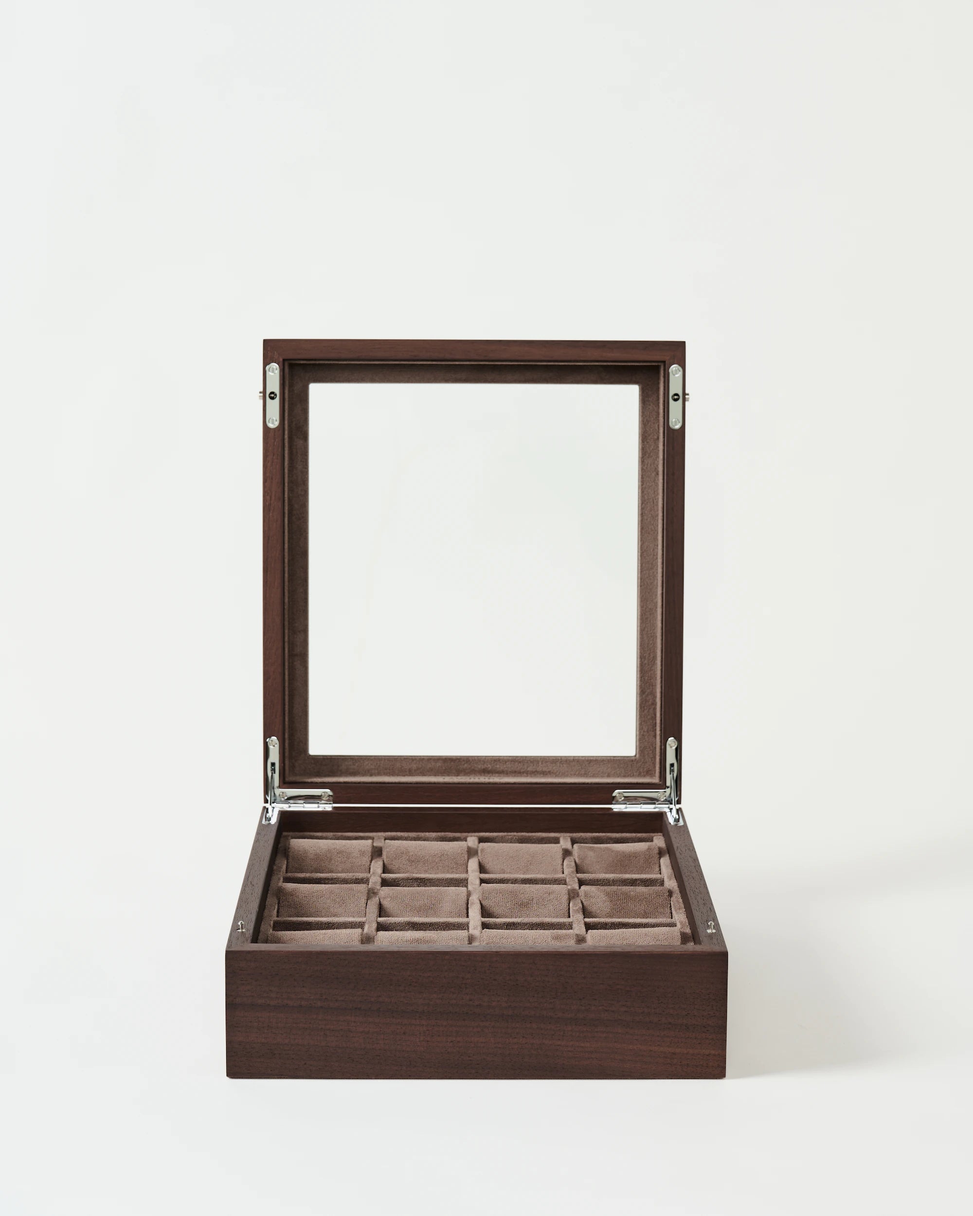 The TAWBURY Grove 12 Slot Wooden Watch Box in Dark Walnut Wood with a glass lid is open, displaying its soft compartments for watches or jewelry against a plain white background.