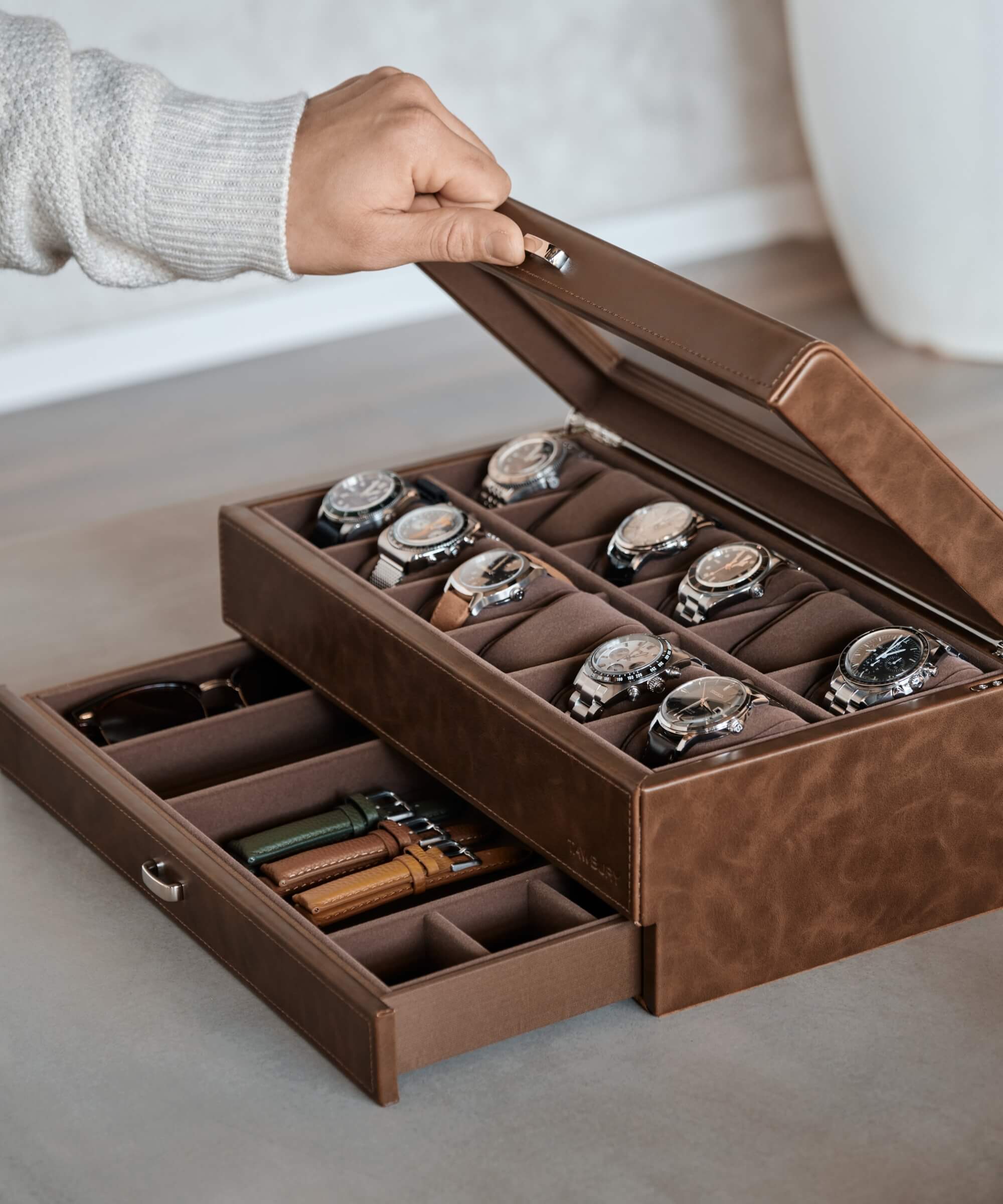 A person displaying a TAWBURY Bayswater 12 Slot Watch Box with Drawer - Brown for storage.