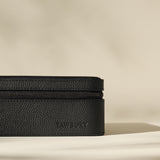 A close-up of the Fraser 6 Watch Case in black by TAWBURY, showing its textured rectangular design, zipper closure, and subtle side embossing—ideal for storing your watches in style.