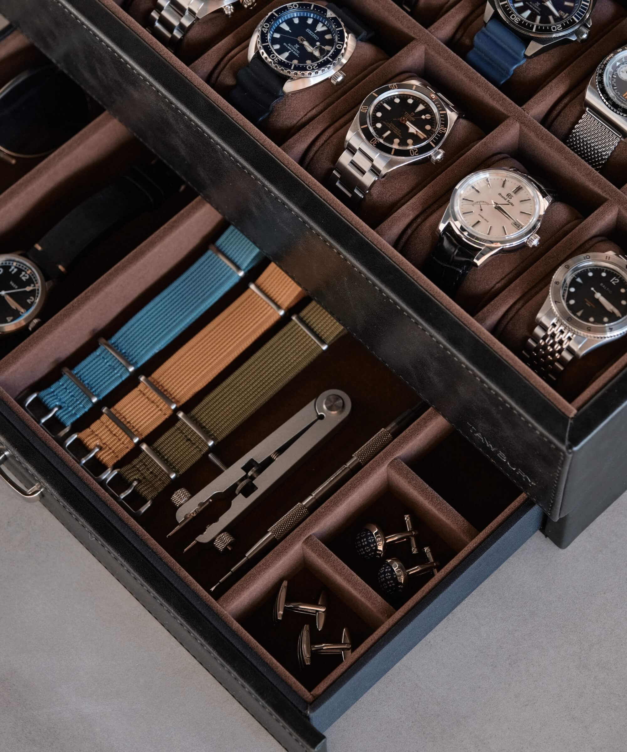A TAWBURY Bayswater 12 Slot Watch Box with Drawer - Black filled with timepieces.