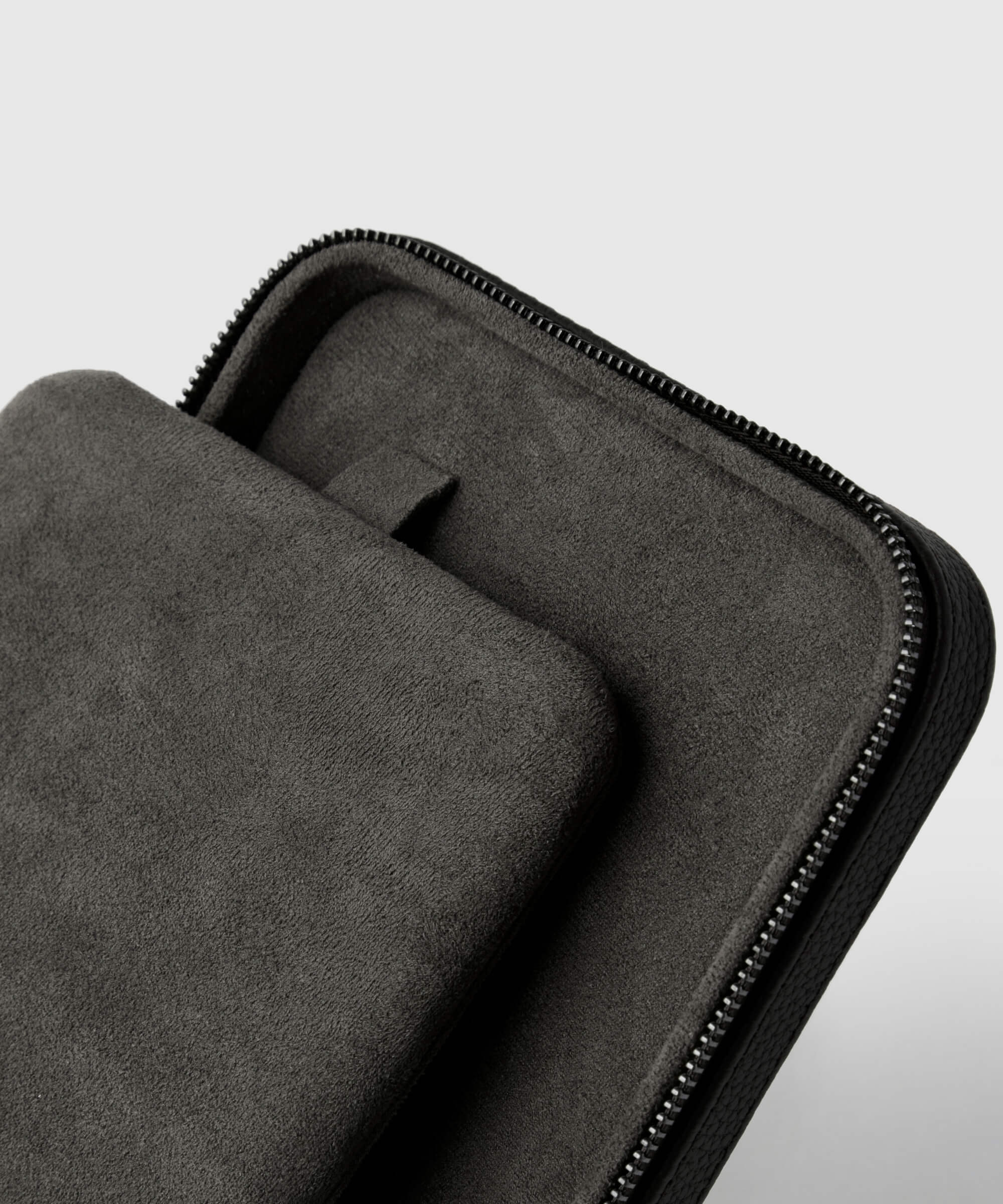 Close-up of a black luxury leather Fraser 6 Watch Travel Case - Black (Coming Soon), partially open to reveal an inner compartment and a fabric tab. The material appears soft and textured, exuding the quality synonymous with the TAWBURY range.