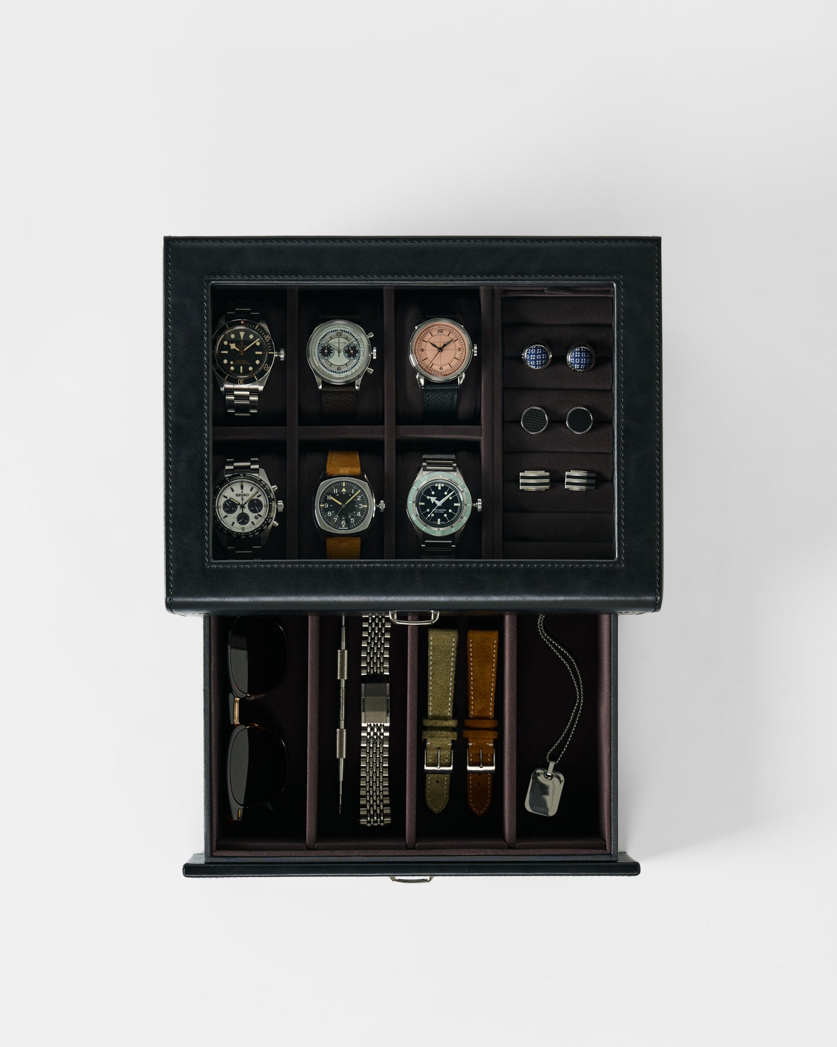 The TAWBURY Bayswater 6 Watch Jewelry Box in Black/Charcoal stores six watches, four pairs of cufflinks, two rings, sunglasses, three straps, a bracelet, and a dog tag—perfect for organized and elegant storage.