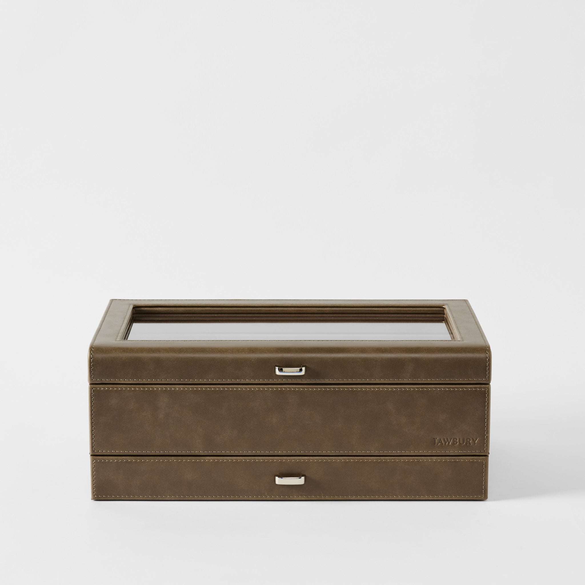 The TAWBURY Bayswater 12 Slot Watch Box with Storage in Driftwood Taupe features a closed glass top and two silver handles, displayed against a plain white background.