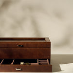 The TAWBURY Bayswater 12 Slot Watch Box with Storage in brown, featuring organized compartments and a partially open drawer, is displayed on a neutral background.