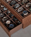 A Tawbury Bayswater 24 Slot Watch Box with Drawer - Brown filled with an exquisite collection of timepieces, perfect for watch enthusiasts.