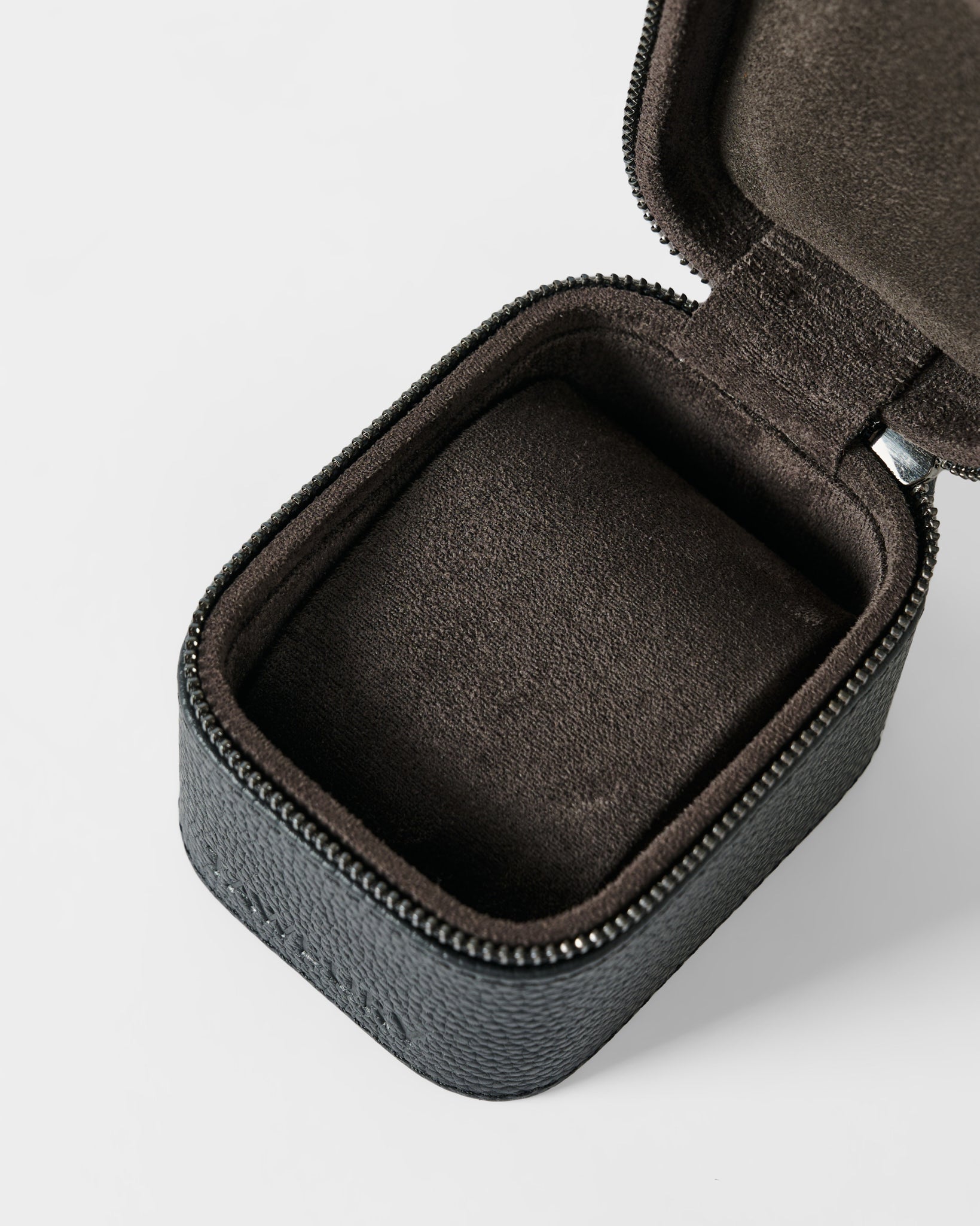 The TAWBURY Fraser 1 Watch Case - Black is shown open and empty, with a zipper and dark brown velvet-like lining, photographed on a white background.