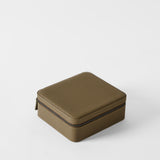 The TAWBURY Fraser 6 Watch Case in Truffle Taupe is a sleek, square leather box on a white surface, elegantly organizing up to six watches.