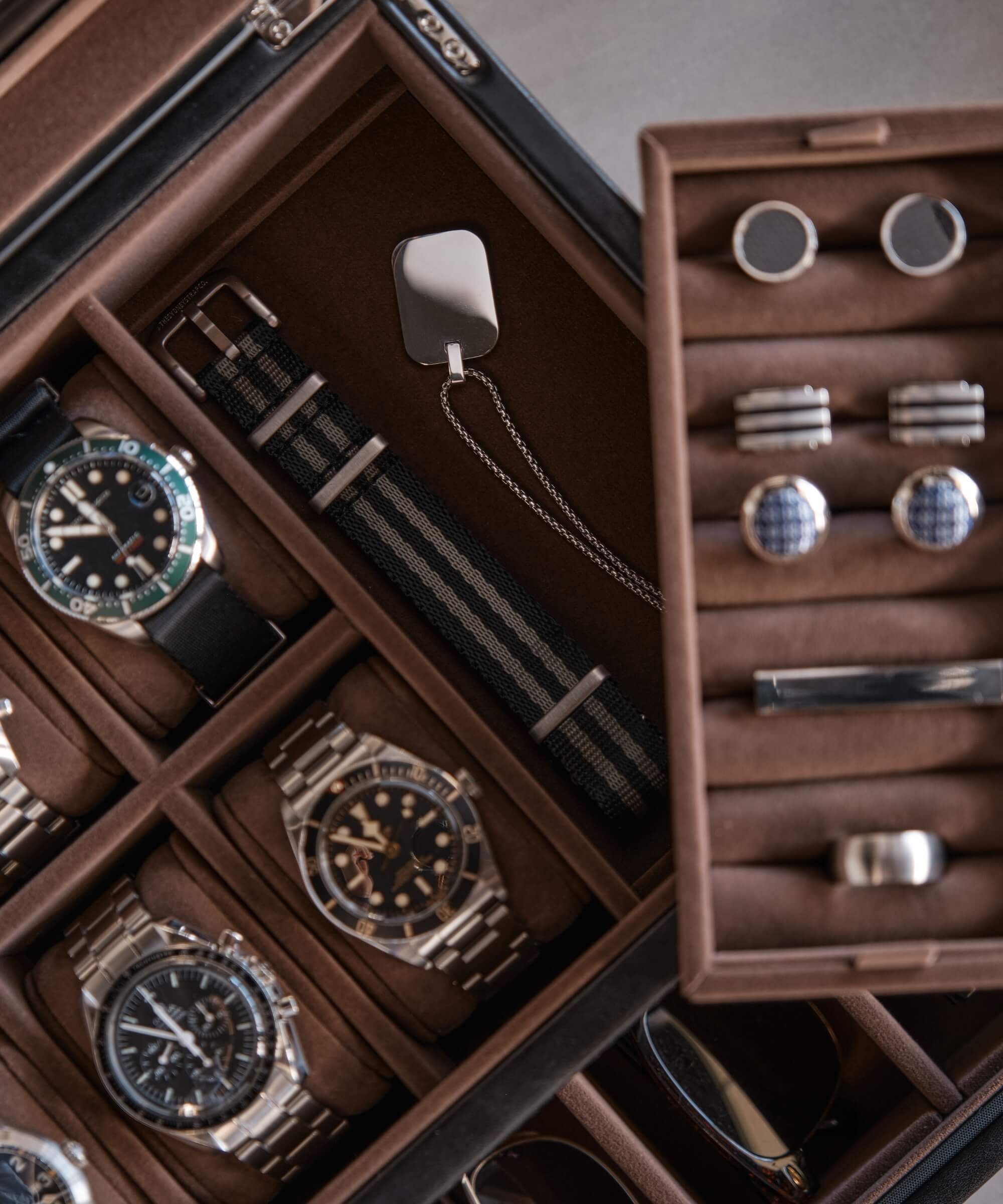 A TAWBURY Bayswater 6 Watch Jewellery Box - Black filled with timepieces, cufflinks, and other lifestyle accessories.