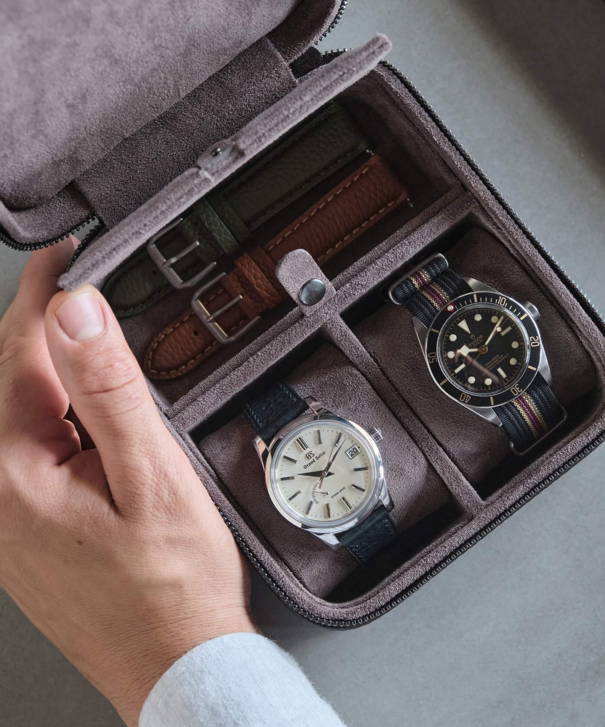 A watch lover is holding two TAWBURY Fraser 2 Watch Travel Cases with Storage - Brown.