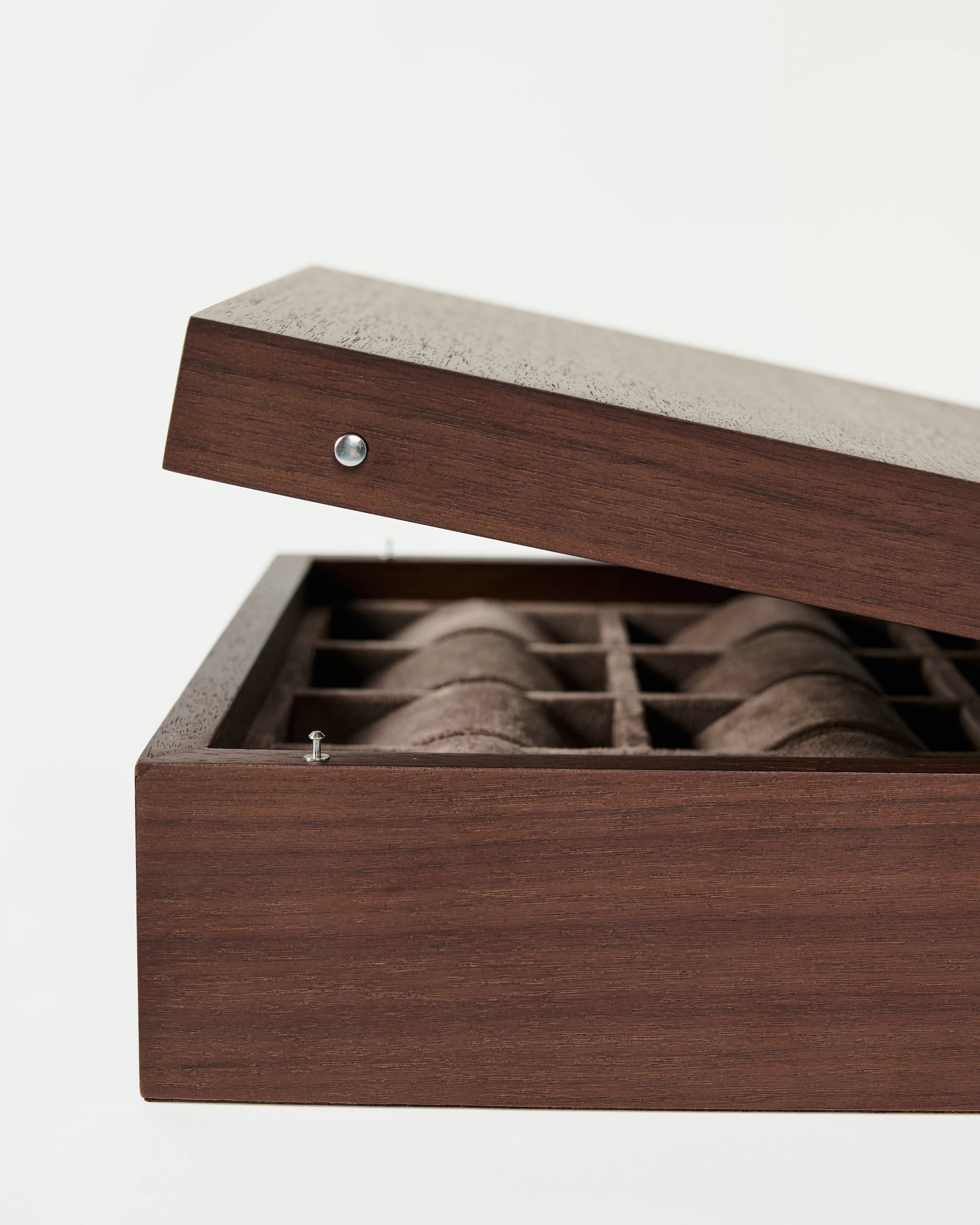 The TAWBURY Grove 12 Slot Wooden Watch Box in dark walnut wood features a solid lid and a grid of padded compartments for organizing your watches.