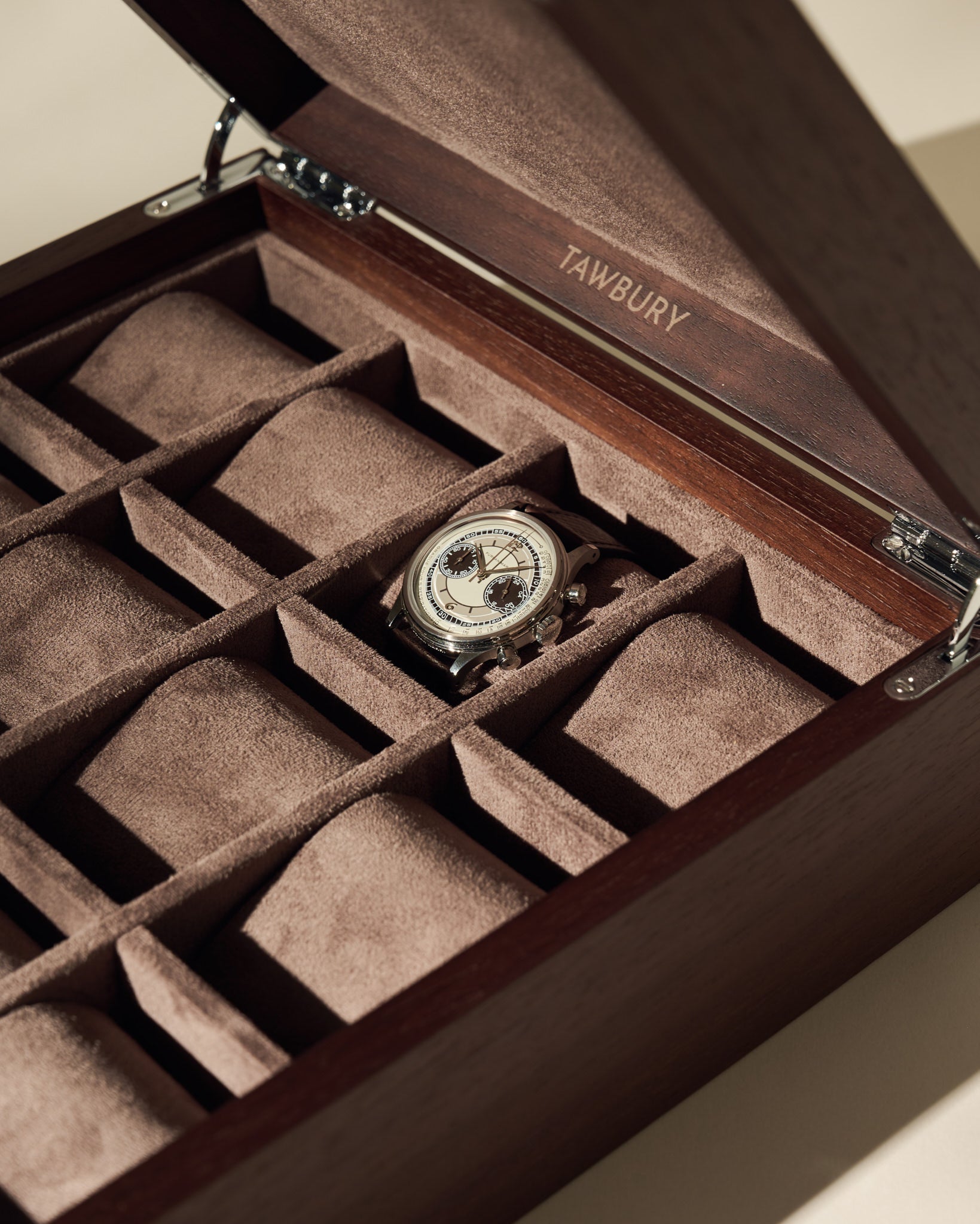 A single wristwatch is shown in the TAWBURY Grove 12 Slot Wooden Watch Box, crafted from dark walnut wood with a solid lid and suede-lined compartments—ideal for organizing your collection.