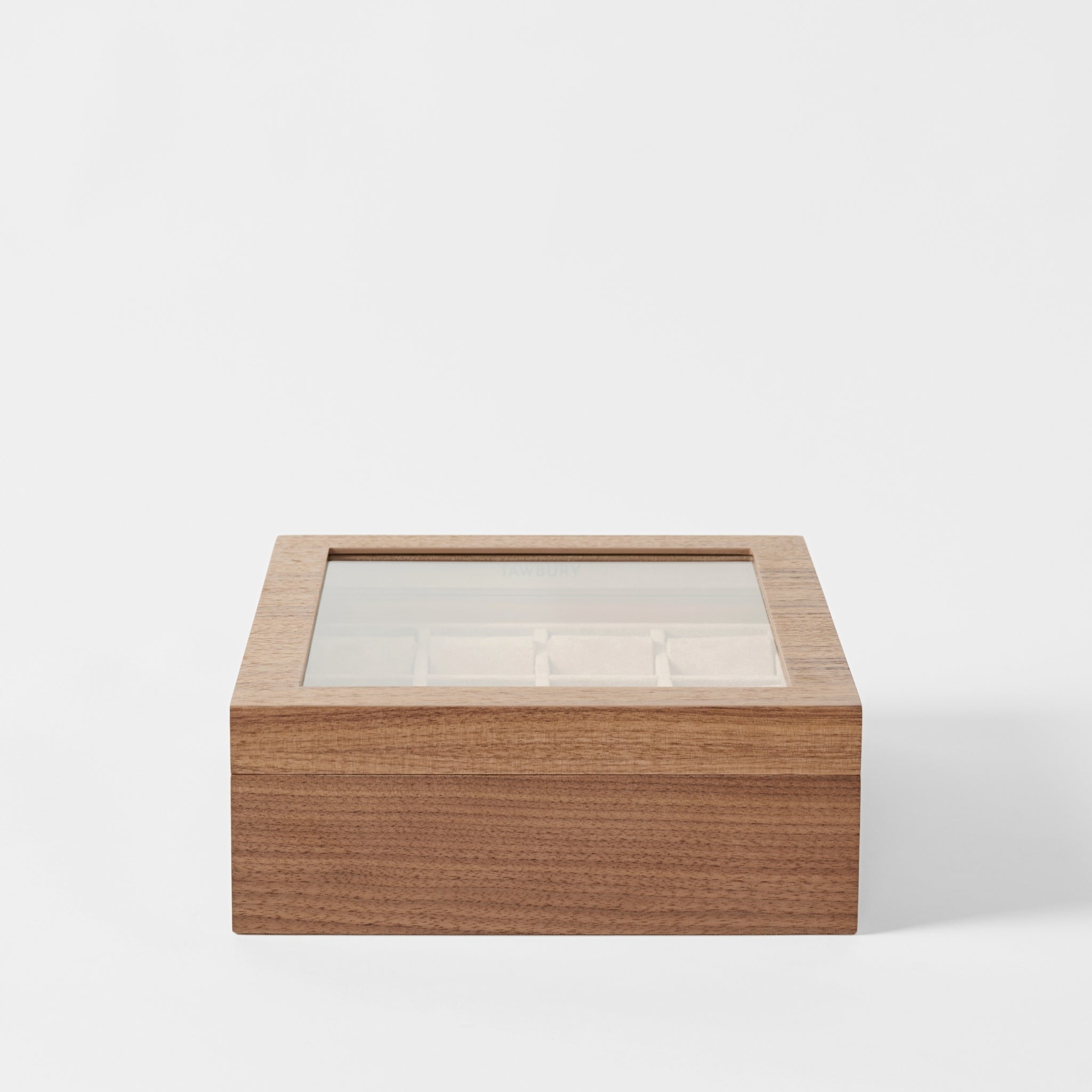 The TAWBURY Grove 12 Slot Wooden Watch Box in classic walnut wood features a glass lid and divided compartments, displayed against a plain white background.