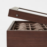 The TAWBURY Grove 12 Slot Wooden Watch Box in dark walnut features a glass lid and multiple cushioned compartments—perfect for collectors to stylishly display and protect their watches.