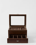 The TAWBURY Bayswater 6 Watch Jewelry Box in brown features a glass lid, multiple top compartments for watches, and an open drawer with additional divided sections for organized jewelry storage.