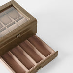 The TAWBURY Bayswater 8 Slot Watch Box with Storage in taupe features a glass lid, padded watch pillows on top, and a lower drawer with divided sections, displayed against a plain white background.