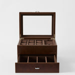 The TAWBURY Bayswater 6 Watch Jewelry Box in chestnut brown faux leather features a glass lid, multiple top compartments for rings and watches, plus an open drawer with six sections for organized watch storage.