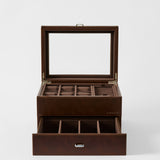 The TAWBURY Bayswater 6 Watch Jewelry Box in chestnut brown faux leather features a glass lid, multiple top compartments for rings and watches, plus an open drawer with six sections for organized watch storage.