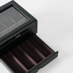 The TAWBURY Bayswater 8 Slot Watch Box with Storage in Black/Charcoal features a glass lid, an open drawer, and velvet-lined compartments for stylish watch and accessory display.