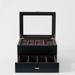 The TAWBURY Bayswater 6 Watch Jewelry Box - Midnight Black features a glass lid, multiple top compartments, a pull-out drawer with extra sections, and brown fabric lining—perfect for organizing your men's watch collection.