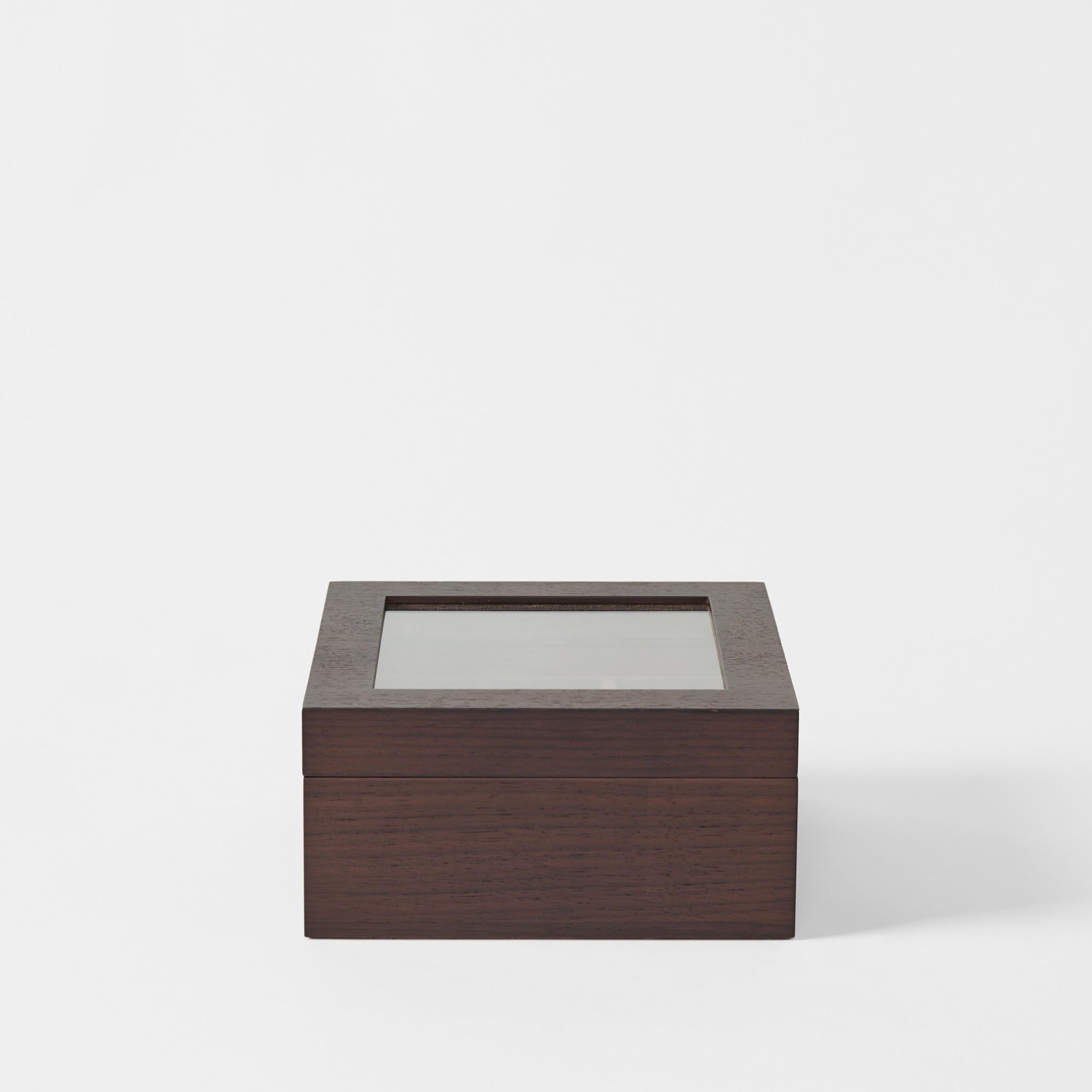 The TAWBURY Grove 6 Slot Wooden Watch Box in dark walnut wood features a glass lid and is displayed against a plain white background.